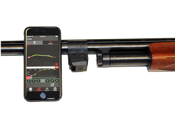 Shotgun with Mantis X10 Attached Showing Phone App Screen While Leaning Against Gun